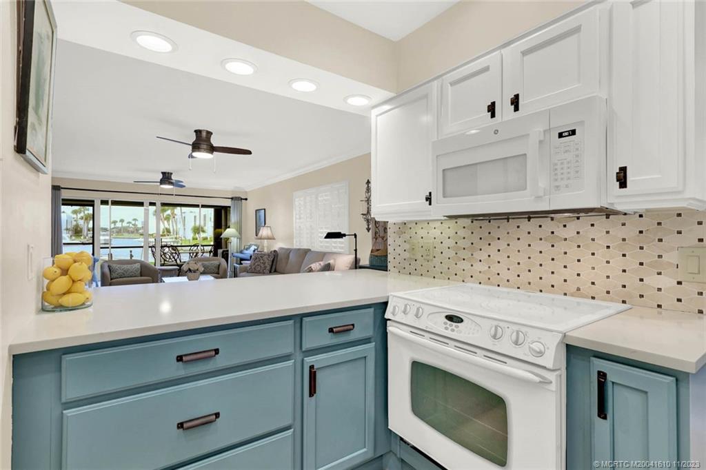 1950 Southwest Palm City Road, Unit 4107 Stuart, FL 34994 - Photo 15 of 65 a kitchen with granite countertop white cabinets and white stainless steel appliances