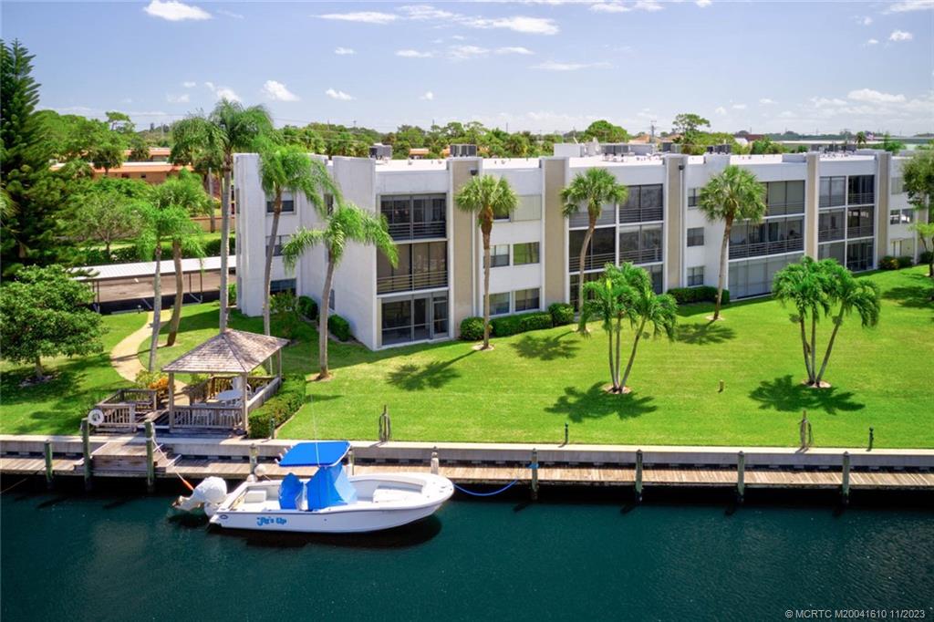 1950 Southwest Palm City Road, Unit 4107 Stuart, FL 34994 - Photo 7 of 65 a view of a lake with a house and a yard