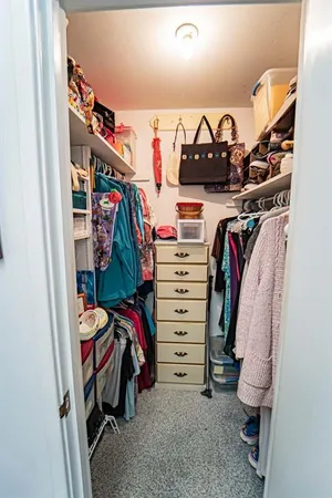 a view of walk in closet with clothes and shoes