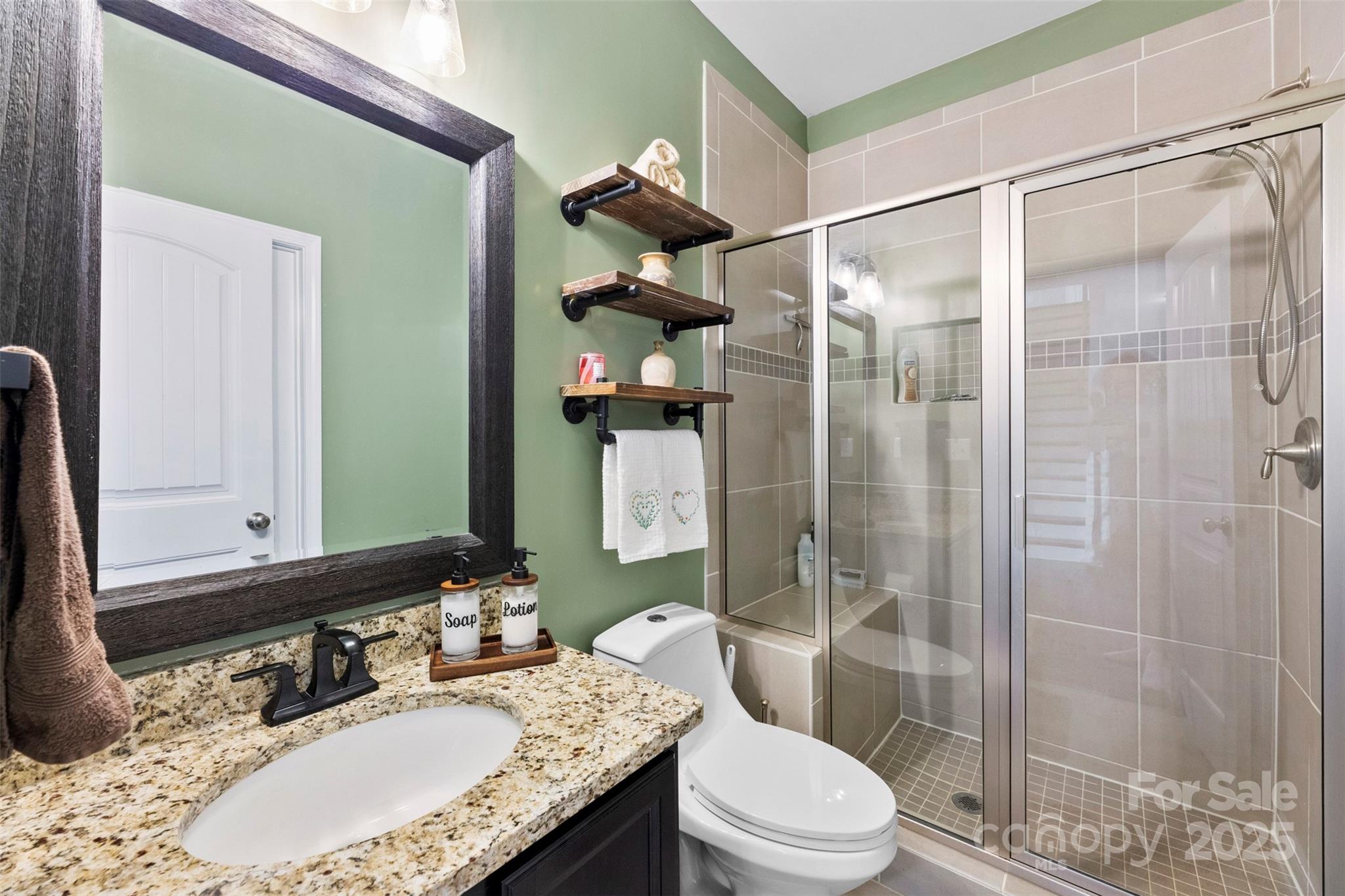 164 Reese Wilson Road Belmont, NC 28012 - Photo 11 of 27 a bathroom with a granite countertop sink a toilet a mirror and shower