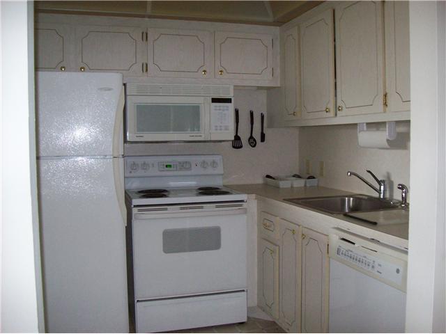 27 Suffolk A, Unit 27 Boca Raton, FL 33434 - Photo 2 of 7 a kitchen with white cabinets and white appliances
