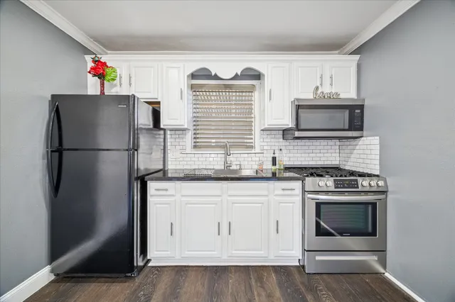 a kitchen with stainless steel appliances granite countertop a refrigerator stove and sink