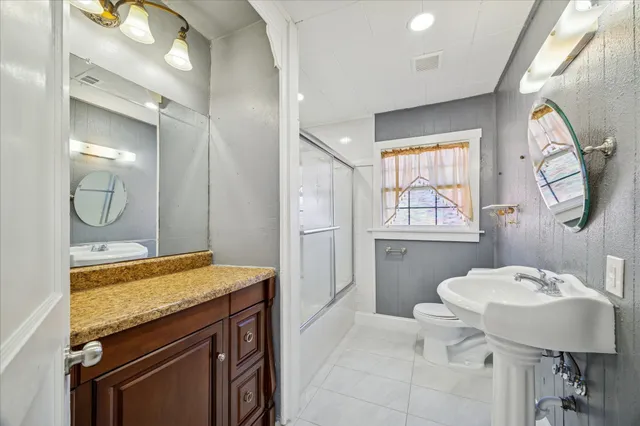 a bathroom with a granite countertop sink a mirror and a bathtub