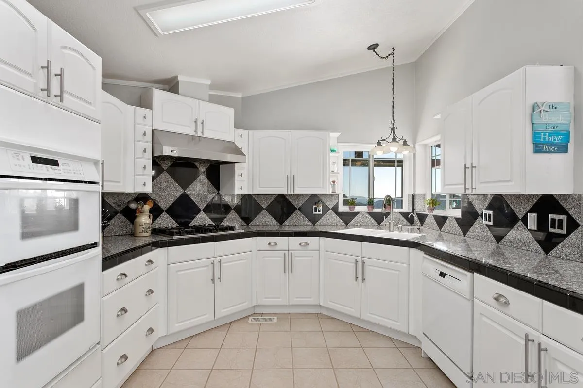 6167 Rainbow Heights Road Fallbrook, CA 92028 - Photo 14 of 44 a kitchen with granite countertop white cabinets and white appliances