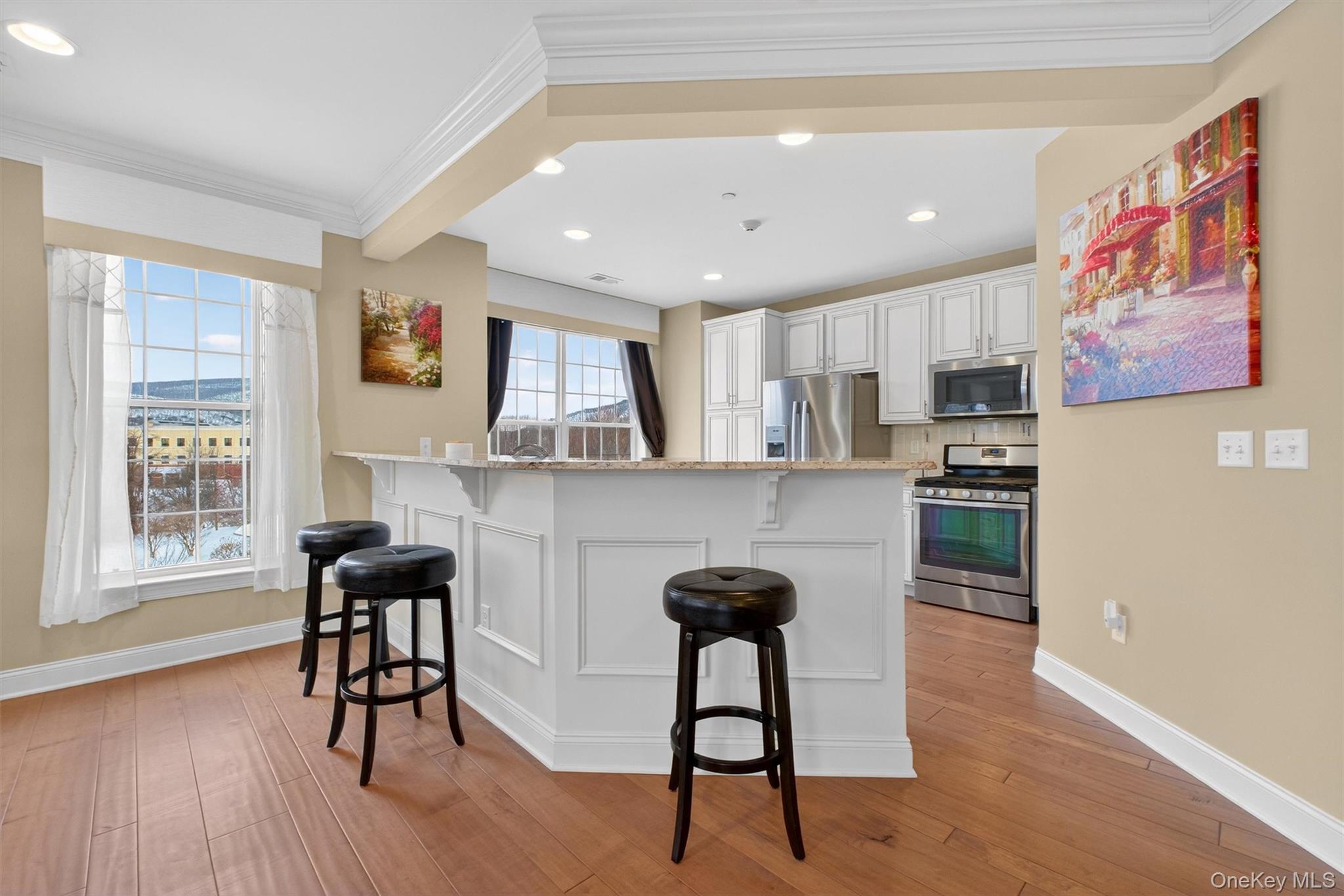 734 Regency Drive Fishkill, NY 12524 - Photo 20 of 50 a kitchen with stainless steel appliances kitchen island granite countertop a refrigerator a stove a dining table and chairs with wooden floor