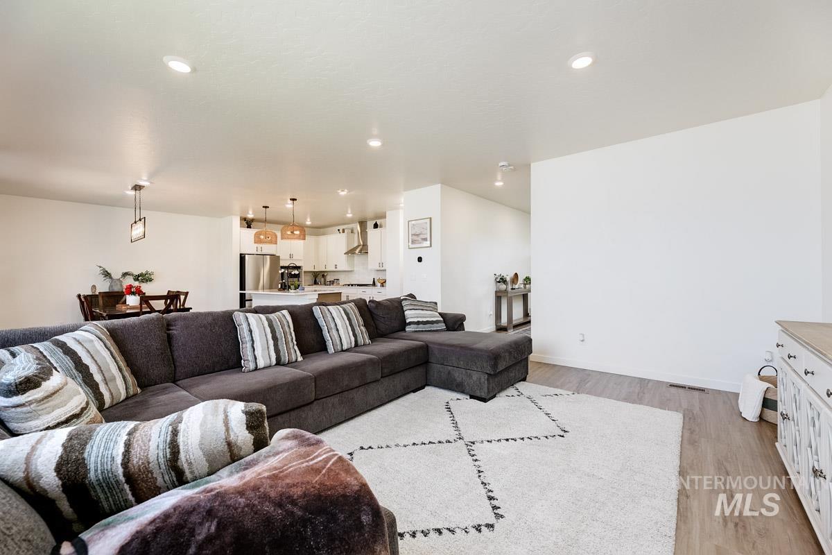 4469 South Colditz Way Meridian, ID 83642 - Photo 13 of 30 Open-concept living space featuring recessed lighting, wood-finish flooring, and a dining area with pendant lighting