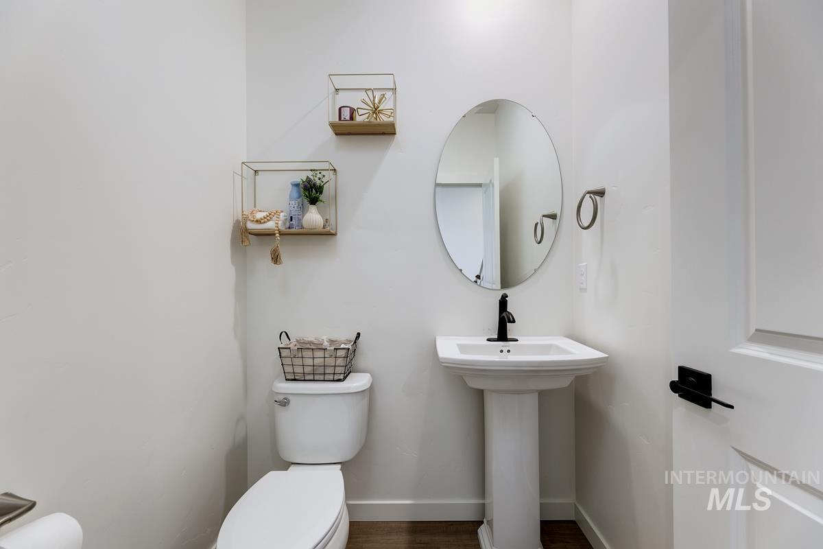 4469 South Colditz Way Meridian, ID 83642 - Photo 14 of 30 Pedestal sink with a matte black faucet, oval mirror, and white walls