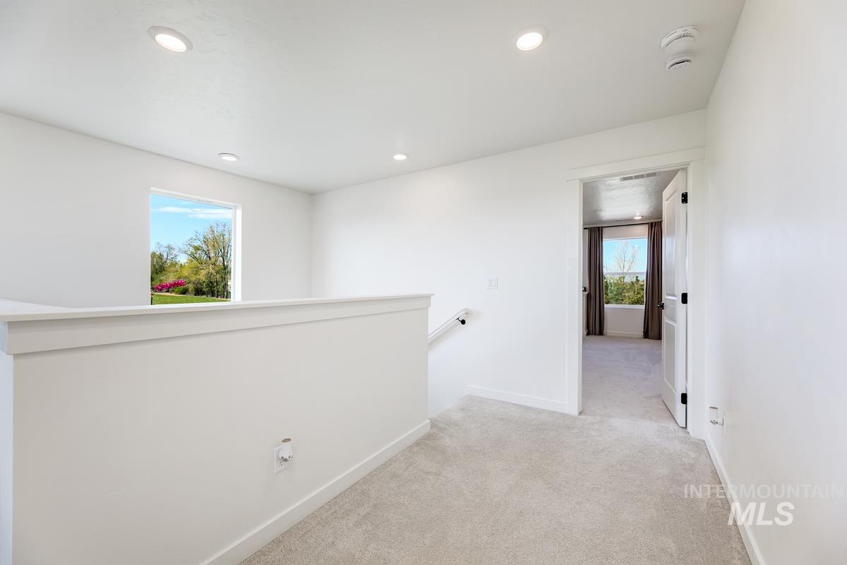 4469 South Colditz Way Meridian, ID 83642 - Photo 15 of 30 Carpeted landing featuring recessed lighting, a white painted railing, and an open doorway to another room