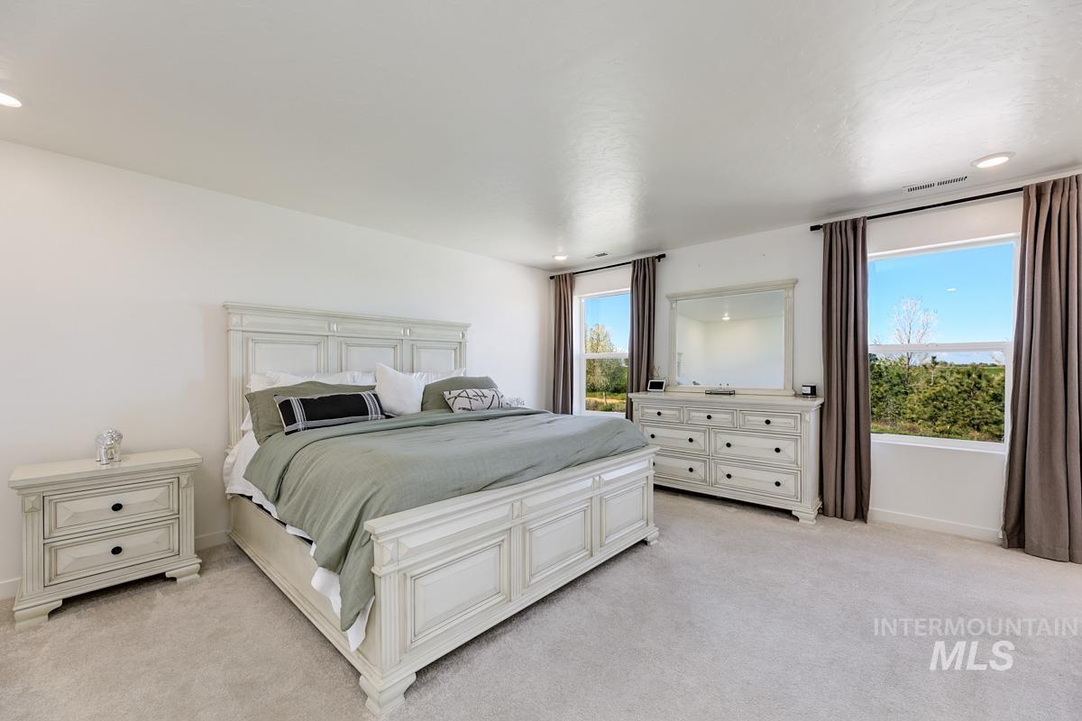4469 South Colditz Way Meridian, ID 83642 - Photo 16 of 30 Spacious bedroom featuring light-colored carpeting, recessed lighting, and two large windows with dark drapery