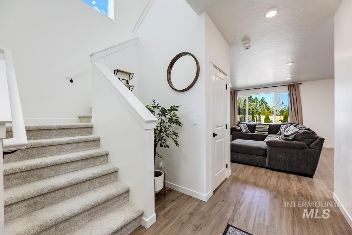 4469 South Colditz Way Meridian, ID 83642 - Photo 3 of 30 Inviting entry featuring a carpeted staircase, high ceilings, and wood-finish flooring