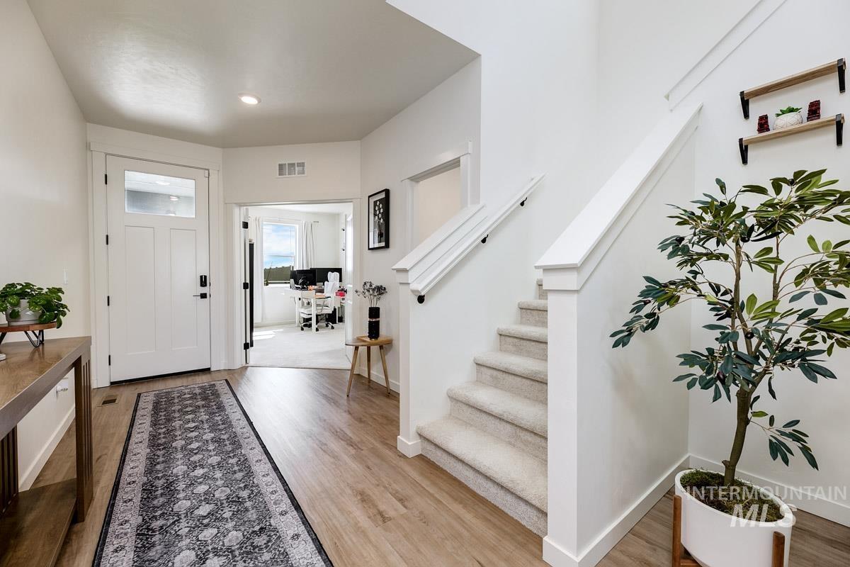 4469 South Colditz Way Meridian, ID 83642 - Photo 4 of 30 Entryway featuring wood-finish flooring and a carpeted staircase with white risers