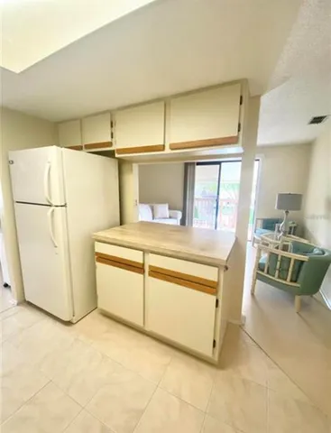 a kitchen with stainless steel appliances a refrigerator and a more cabinets