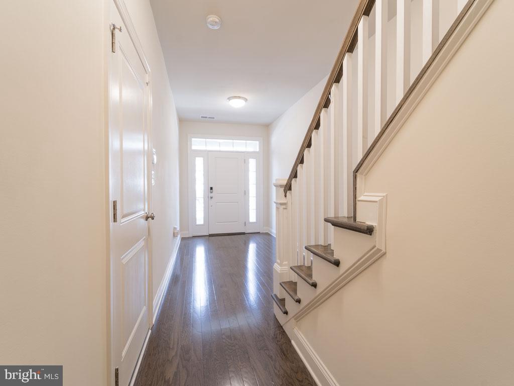 22595 Windsor Locks Square Ashburn, VA 20148 - Photo 33 of 56 a view of a hallway with wooden floor and staircase