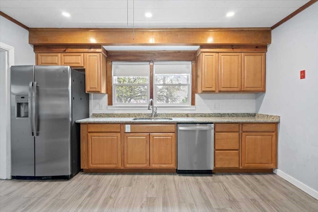 131 South Main Street Clinton, MA 01510 - Photo 13 of 36 a kitchen with stainless steel appliances granite countertop a refrigerator a sink and white cabinets with wooden floor