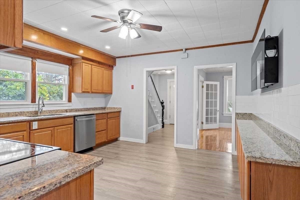 131 South Main Street Clinton, MA 01510 - Photo 15 of 36 a open kitchen with stainless steel appliances granite countertop a refrigerator a sink dishwasher a stove and white countertops with wooden floor