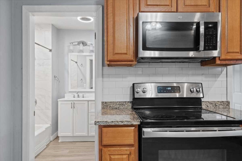 131 South Main Street Clinton, MA 01510 - Photo 17 of 36 a kitchen with stainless steel appliances granite countertop white cabinets and a stove top oven