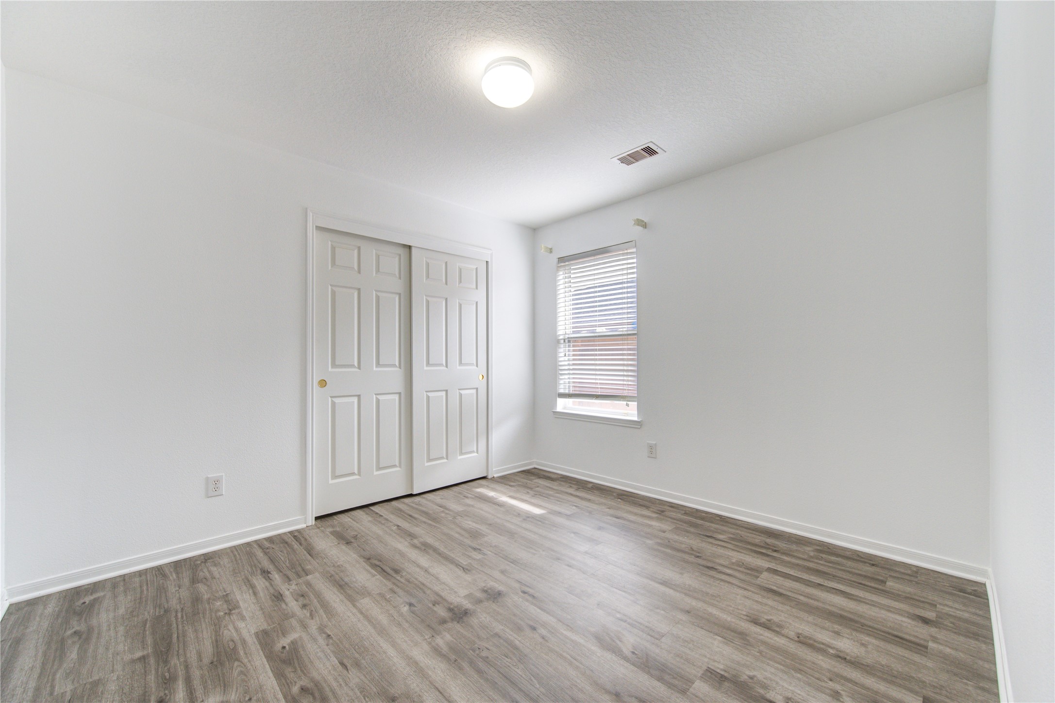 14315 Acorn Ridge Way Cypress, TX 77429 - Photo 20 of 22 an empty room with wooden floor and windows