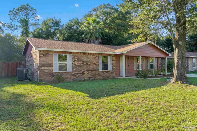a front view of a house with a yard and trees