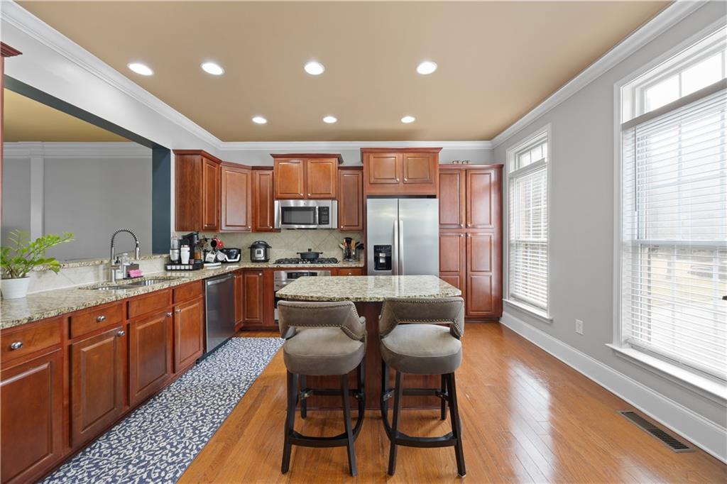 2871 Overlook Way Atlanta, GA 30324 - Photo 4 of 32 a large kitchen with kitchen island granite countertop wooden cabinets and stainless steel appliances