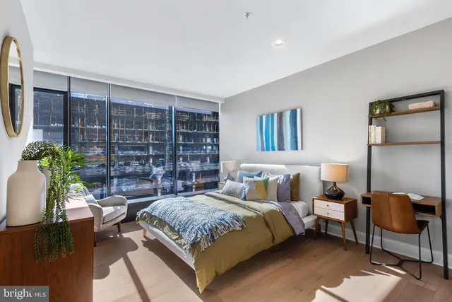 a bedroom with a large bed and a potted plant