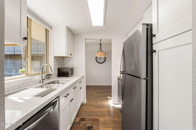a kitchen with a refrigerator sink and cabinets