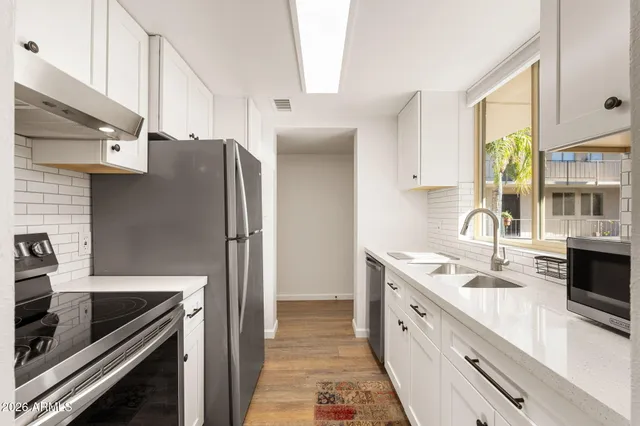 a kitchen with stainless steel appliances granite countertop a sink stove and refrigerator