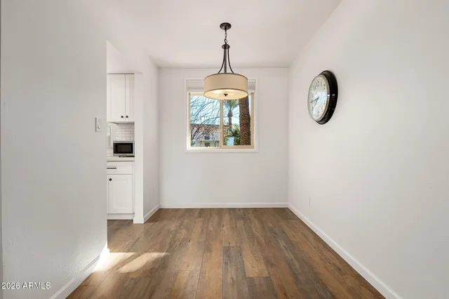 a view of a room with wooden floor chandelier and windows