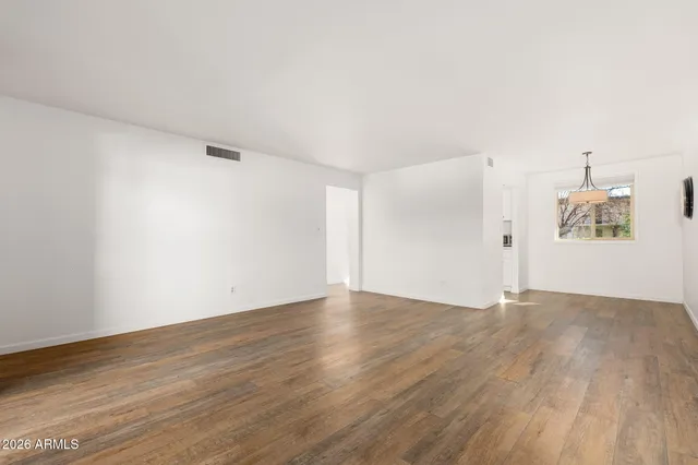 a view of empty room with wooden floor