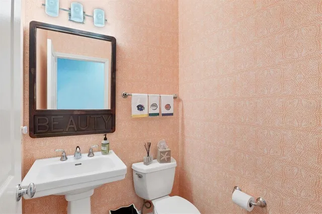 a bathroom with a toilet a sink and mirror