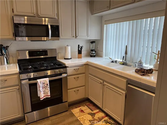 a kitchen with granite countertop cabinets stainless steel appliances and a sink
