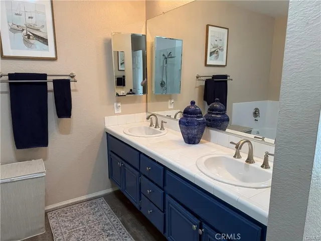 a bathroom with double vanity sink a mirror and a toilet