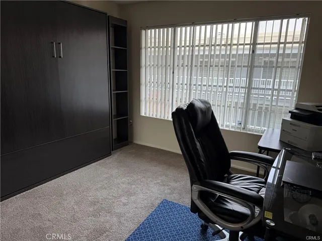a view of a workspace with furniture and a window