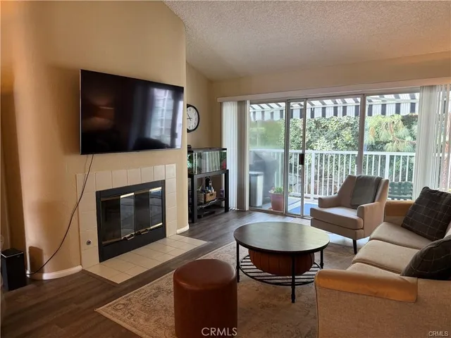 a living room with furniture a flat screen tv and a fireplace