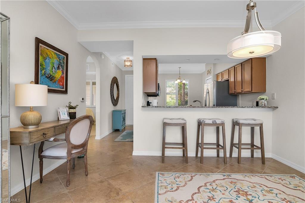 9719 Acqua Court, Unit 214 Naples, FL 34113 - Photo 6 of 50 a living room with furniture a dining table and a chandelier