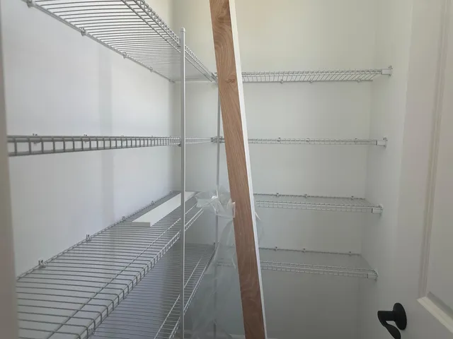 a kitchen with kitchen island granite countertop a stove a sink a center island a refrigerator and a wooden floor