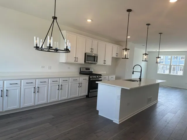 a kitchen with stainless steel appliances a refrigerator and a stove top oven