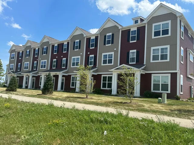 a front view of a residential apartment building with a yard