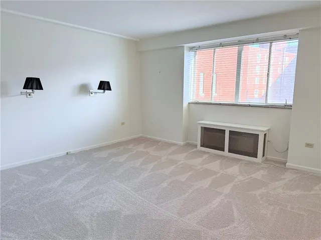 an empty room with windows and fireplace