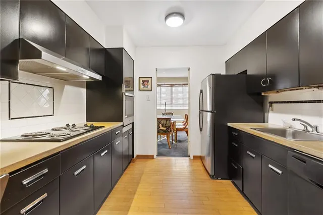 a kitchen with stainless steel appliances granite countertop a sink stove and refrigerator