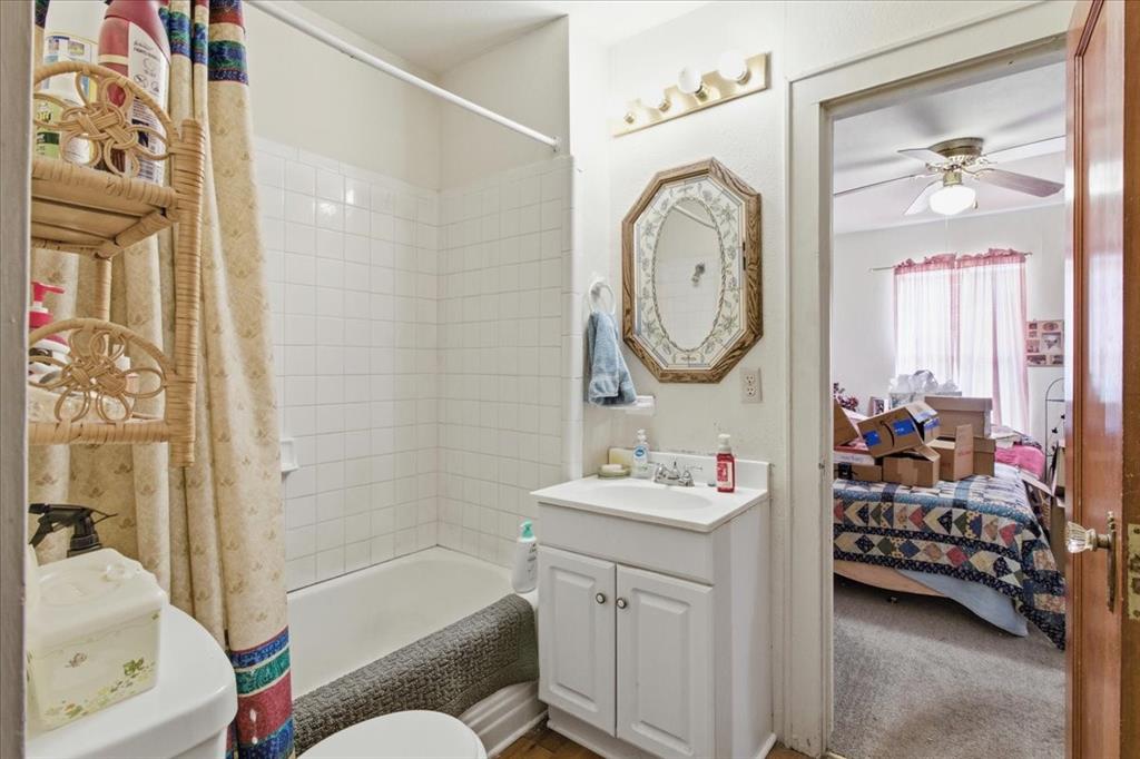 1000 West Morgan Street Denison, TX 75020 - Photo 18 of 30 Bathroom featuring vanity, shower / bath combination with curtain, connected bathroom, and ceiling fan