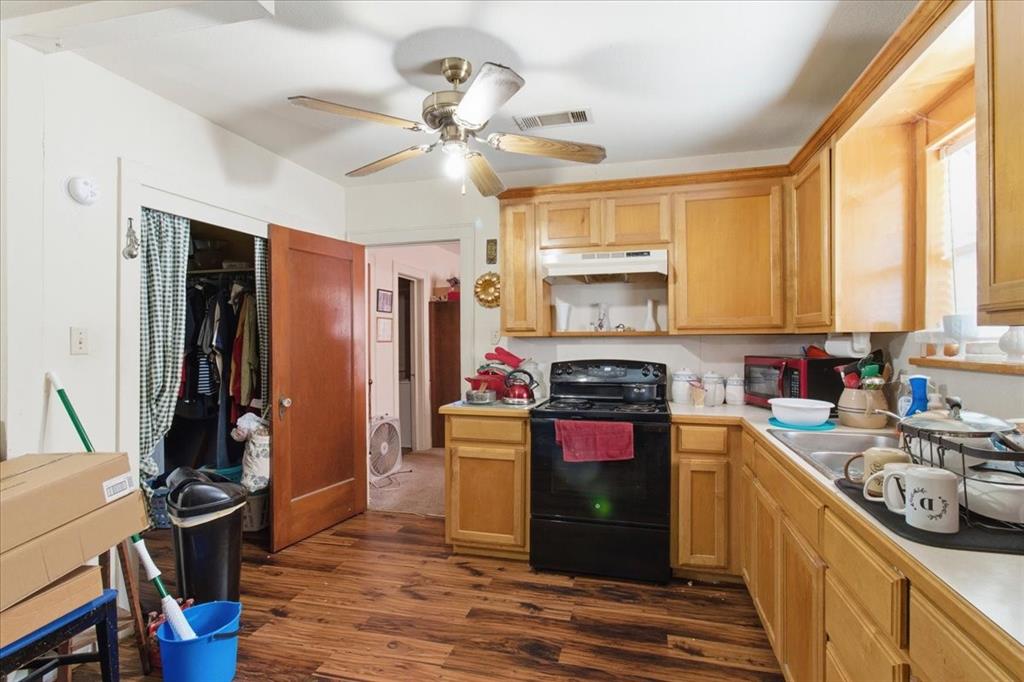 1000 West Morgan Street Denison, TX 75020 - Photo 9 of 30 Kitchen with black range with electric stovetop, dark wood-style floors, light countertops, ceiling fan, and under cabinet range hood