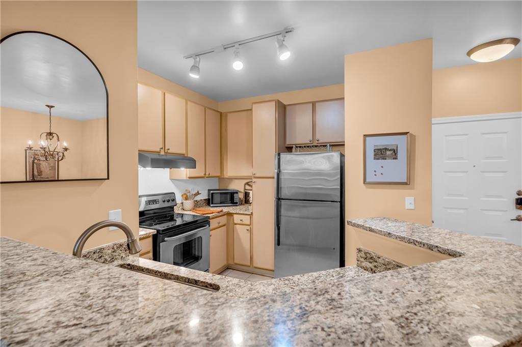 821 Ralph McGill Boulevard Northeast, Unit 2303 Atlanta, GA 30306 - Photo 11 of 43 a kitchen with stainless steel appliances granite countertop a sink a stove a refrigerator cabinets and a dining table