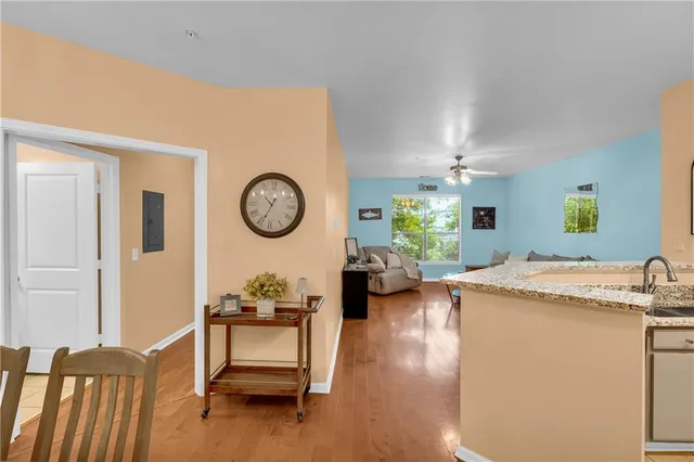 a kitchen with kitchen island a stove a sink dishwasher and white cabinets with wooden floor