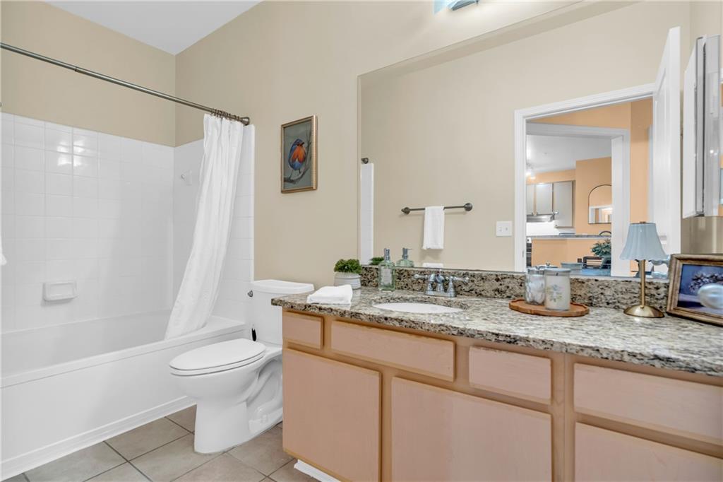 821 Ralph McGill Boulevard Northeast, Unit 2303 Atlanta, GA 30306 - Photo 23 of 43 a bathroom with a granite countertop sink mirror vanity and toilet