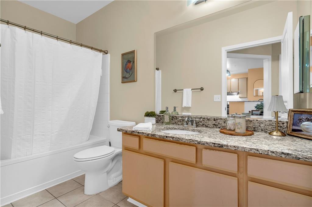 821 Ralph McGill Boulevard Northeast, Unit 2303 Atlanta, GA 30306 - Photo 24 of 43 a bathroom with a granite countertop sink mirror vanity and toilet