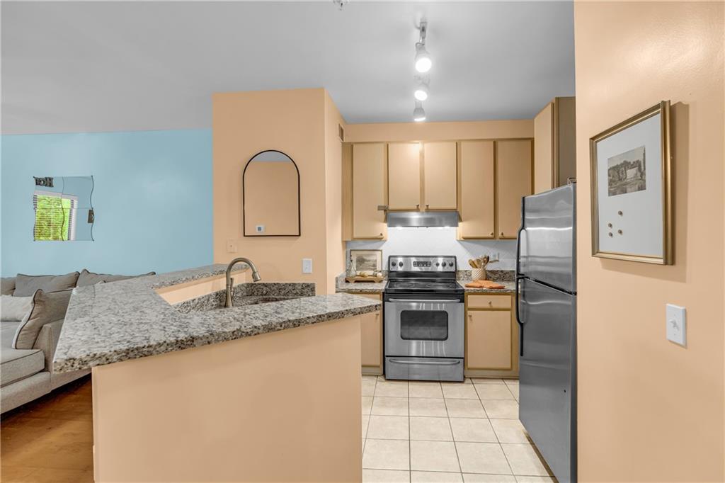 821 Ralph McGill Boulevard Northeast, Unit 2303 Atlanta, GA 30306 - Photo 6 of 43 a kitchen with stainless steel appliances granite countertop a sink stove and refrigerator