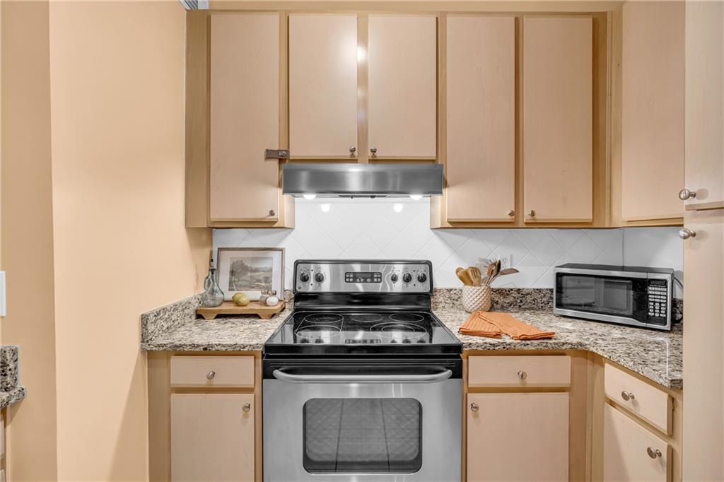 821 Ralph McGill Boulevard Northeast, Unit 2303 Atlanta, GA 30306 - Photo 8 of 43 a kitchen with stainless steel appliances granite countertop a stove a sink and white cabinets