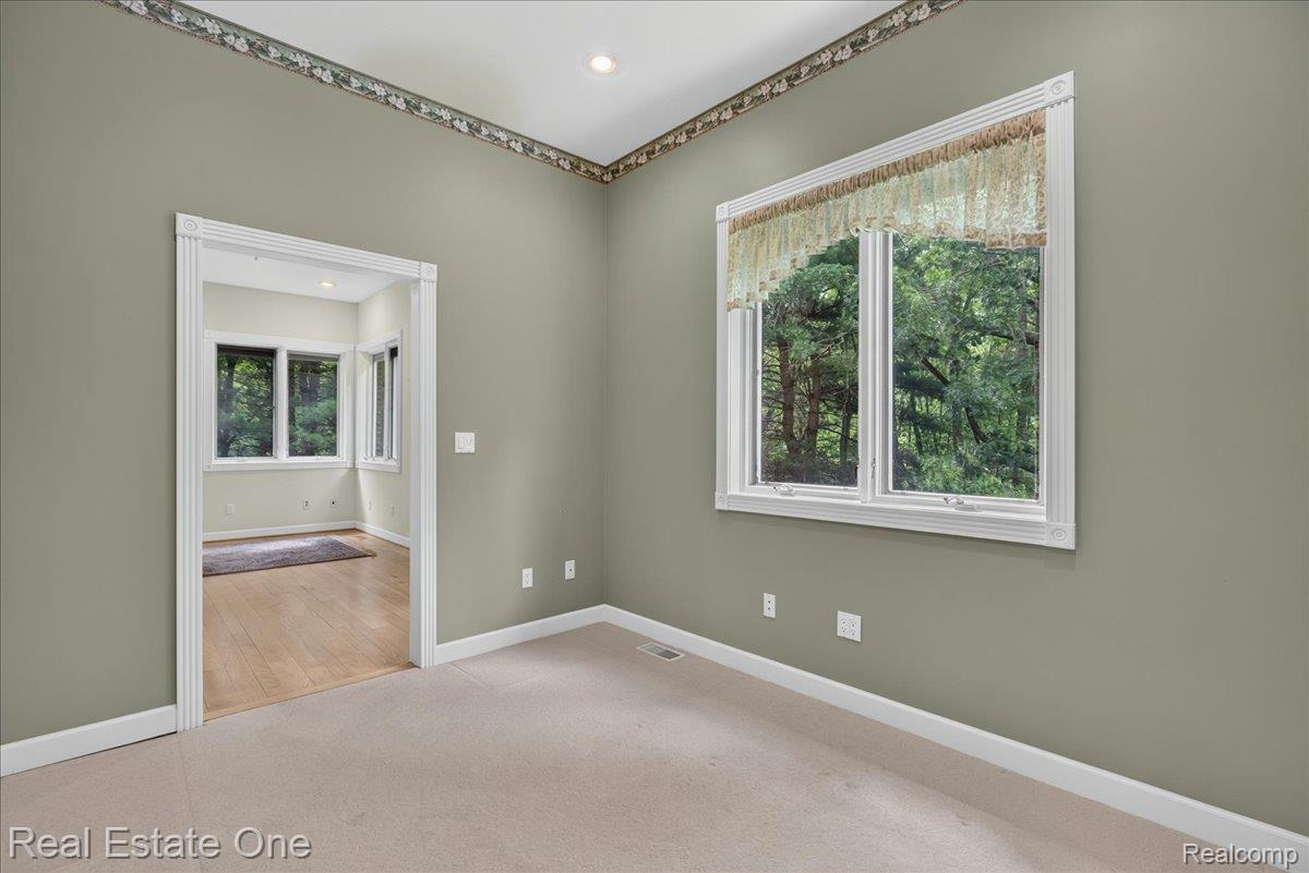 425 Courtney Road Leonard, MI 48367 - Photo 53 of 89 Room featuring neutral carpeting, a large window, recessed lighting, and a doorway with white trim