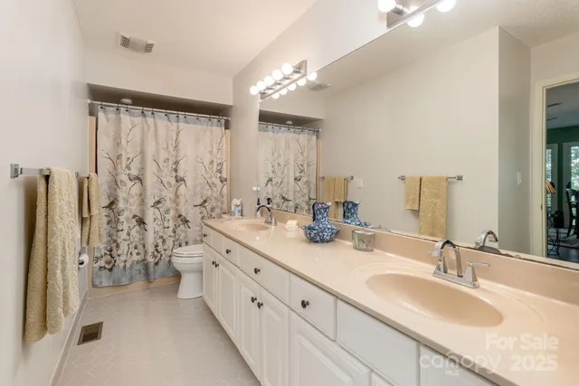 a bathroom with double sink and a mirror