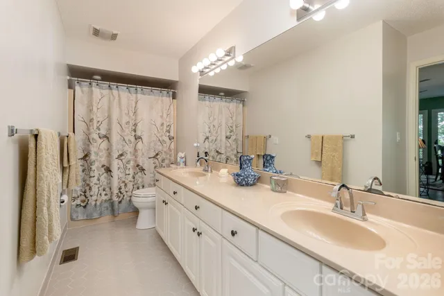 a bathroom with double sink and a mirror